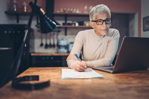 woman at table working on retirement income planning
